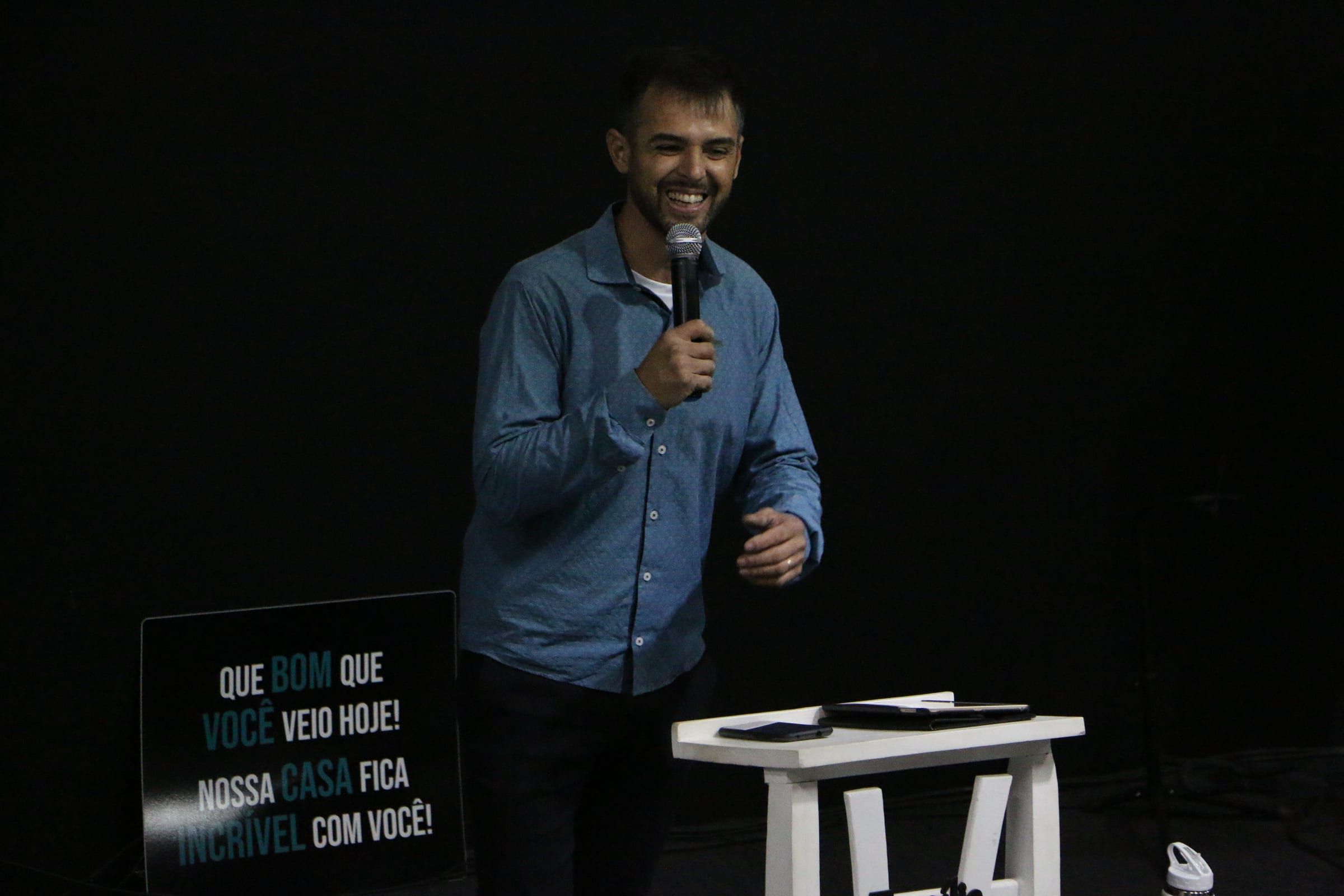 Grupo de pessoas em pé diante do palco da igreja.